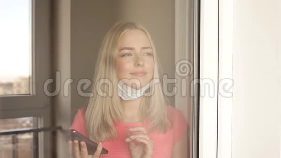 那个戴防护面罩的女人站在她公寓的窗户旁视频的预览图