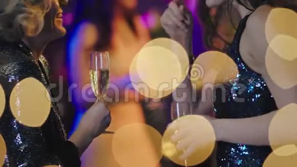 特写细节两位微笑的女士在享受聚会时间她们在社交并拿着一杯香槟视频的预览图