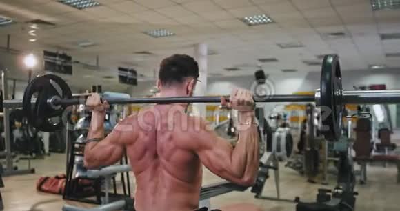 一个有着完美身材的运动员做背部肌肉的运动他的工作非常集中在一个视频的预览图