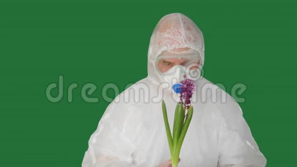 生物工程师穿着防护服口罩和手套手捧花穿着保护服装的男人想开花视频的预览图