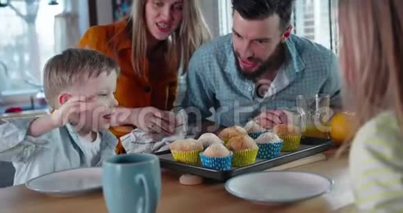 高加索人父母为儿子庆祝生日他微笑着从托盘里拿出一块松饼团结概念慢动作视频的预览图