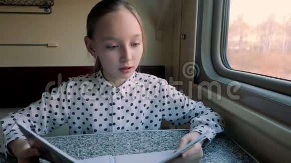 可爱的女孩在火车上读有趣的书视频的预览图
