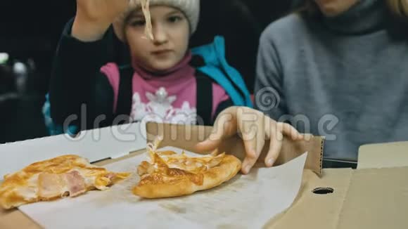 母女俩吃披萨奶酪四块在户外餐馆里吃披萨和咀嚼的年轻女人女孩视频的预览图