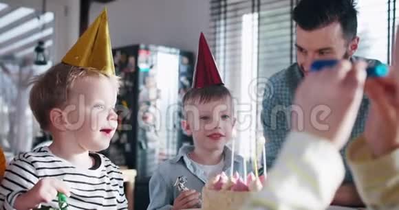 快乐可爱的小白种人男孩挣扎着吹生日蛋糕在家里庆祝有趣的聚会慢动作视频的预览图