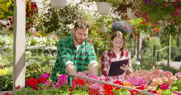 两个园丁在植物间做文书工作视频的预览图