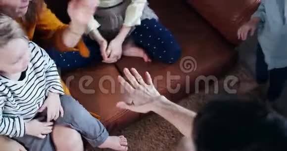 俯视快乐的白种人爸爸妈妈和三个孩子携手开朗的家庭团队合作理念慢动作视频的预览图