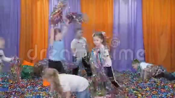 彩色丝带朝不同的方向飞去亮的孩子情绪孩子们抱着彩纸跳起来视频的预览图