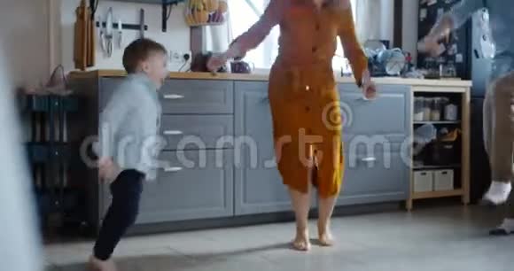 家庭乐趣概念快乐的年轻白种人男孩孩子享受与爸爸妈妈在家跳舞的早晨慢动作视频的预览图
