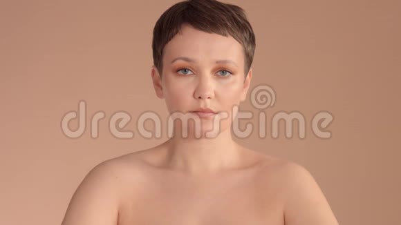 白种人女性短发米色背景的工作室里有天然的米色妆容视频的预览图