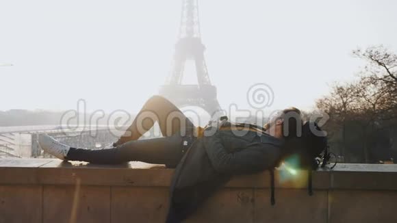快乐的男性游客躺下来放松在史诗般的日落埃菲尔铁塔景巴黎秋假慢动作视频的预览图