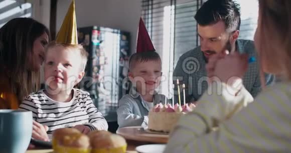 快乐可爱的小欧洲男孩孩子许愿吹生日蛋糕在有趣的庆祝与家庭慢动作视频的预览图
