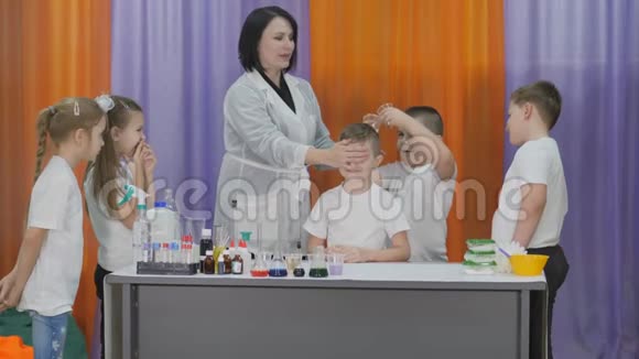 儿童化学实验男孩把化学实验用的液体倒入带有粉末的塑料杯中儿童视频的预览图