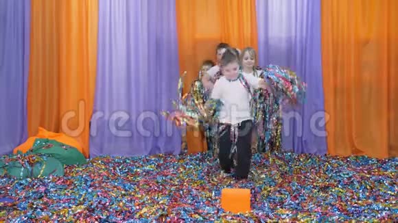 彩色丝带朝不同的方向飞去亮的孩子情绪孩子们抱着彩纸跳起来视频的预览图