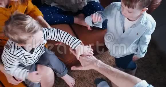 俯视特写年轻开朗的高加索家庭有三个孩子携手快乐的团队合作理念慢动作视频的预览图