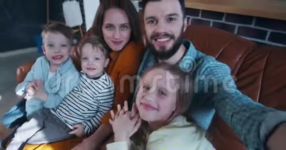 自拍家庭肖像幸福的年轻白种人丈夫与妻子和三个孩子在家慢动作视频的预览图