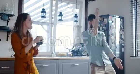 快乐的年轻开朗的白种人男女在现代厨房的早餐跳舞充满朝气的慢动作视频的预览图