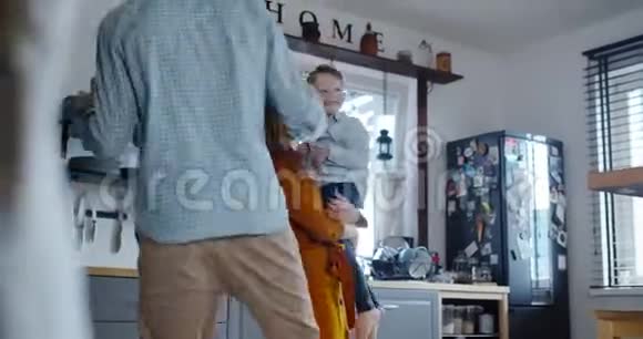 快乐的年轻白种人的母亲和父亲享受玩耍和跳舞与小可爱的儿子在家里慢动作视频的预览图