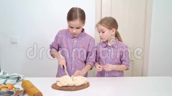 孩子们用刀把面团分成两半放在木板上视频的预览图