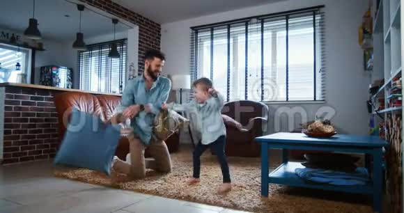 家庭乐趣概念快乐年轻的欧洲父亲与可爱的小儿子对抗枕头在现代轻室慢动作视频的预览图