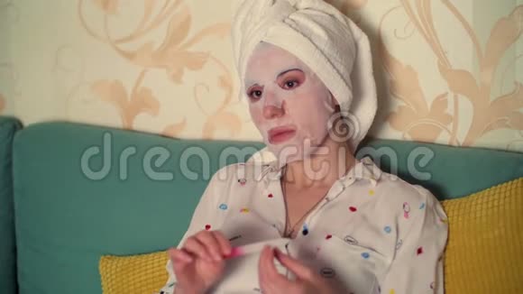 肖像一个女人戴着化妆面料的面具头上戴着一条白色毛巾用指甲锉视频的预览图
