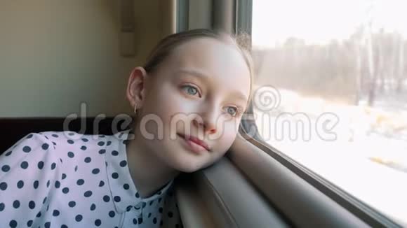 旅行时微笑的女孩头靠在火车窗口肖像旅游女孩看火车旅行窗口视频的预览图