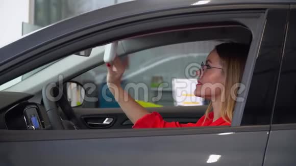 戴眼镜的漂亮女人在车里照镜子视频的预览图