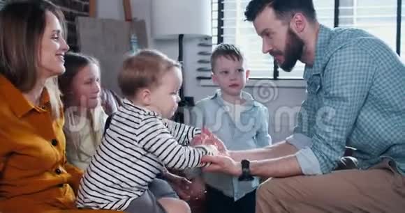 家庭结合时间概念年轻的欧洲父母与小孩子玩手玩有趣的慢动作视频的预览图