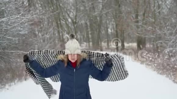 快乐的中年妇女裹着舒适的围巾在冬天散步视频的预览图