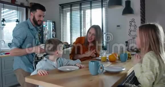 年轻的白种人父亲带着松饼给小儿子在家里和家人一起庆祝有趣的生日聚会视频的预览图