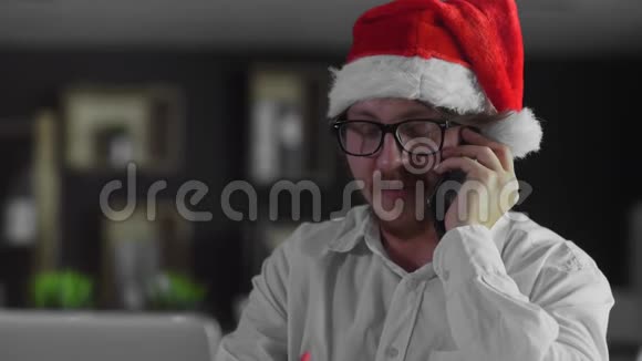 今年圣诞节商人在办公室的智能手机上讲话视频的预览图