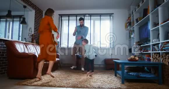 家庭乐趣在家的概念快乐的年轻白种人父亲母亲和小儿子喜欢一起跳舞慢动作视频的预览图