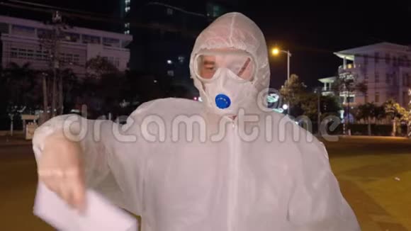 穿着防护服装和面具在亚洲城市街道剪贴板上显示停止冠状病毒标志的人病毒学家视频的预览图