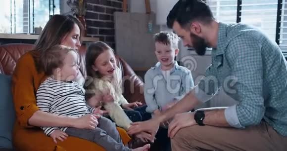 快乐的白种人家庭与三个孩子携手一起振作在一起的时间在家里慢动作视频的预览图