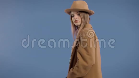 大外套深蓝色背景的金发模特视频的预览图