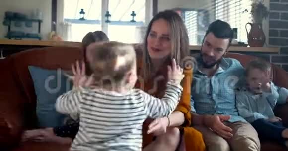 幸福的家庭在一起年轻的高加索父母和三个可爱的微笑的孩子在家分享亲密的时间慢动作视频的预览图