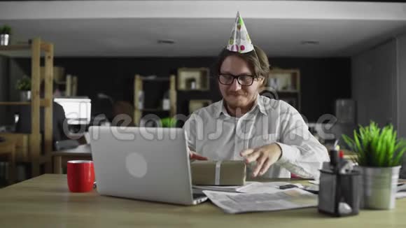 一个商人正在办公室里开生日礼物视频的预览图
