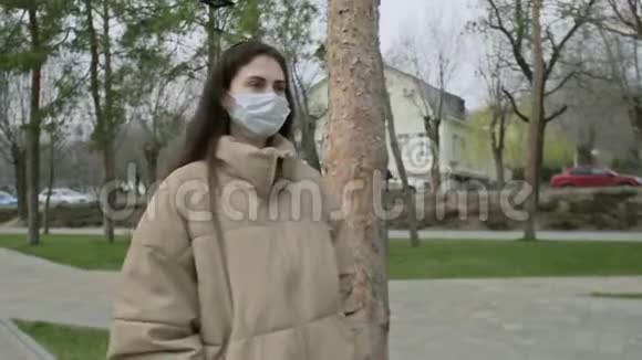 患有医疗面罩的患病妇女在一个空城中心冠状病毒COVID19流行流行期间咳嗽视频的预览图