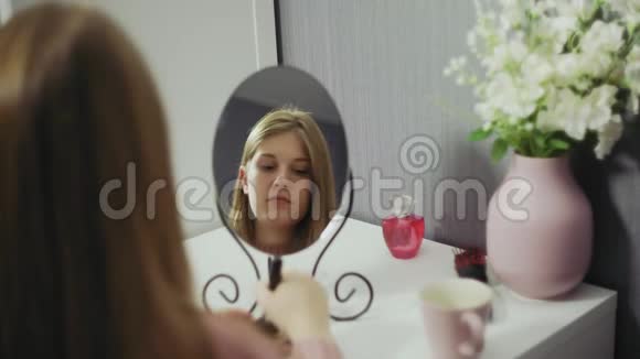美女化妆喝茶美丽的女孩照镜子用一个大的化妆品视频的预览图