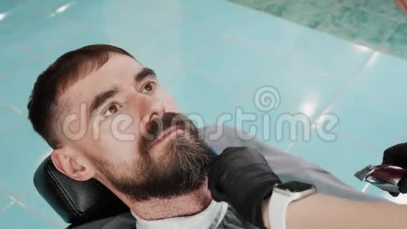 理发店用剃须机和梳子修剪胡须的人发型师用电切男胡须视频的预览图