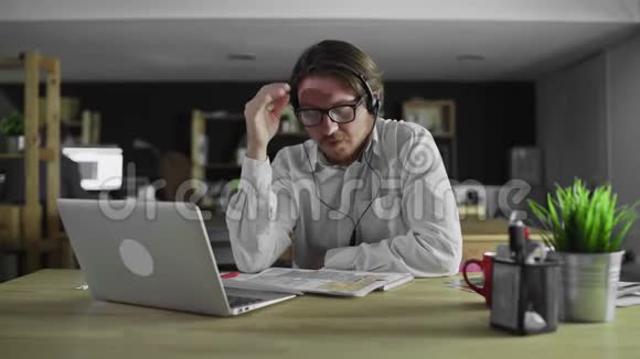 疲惫的经理正在办公室用笔记本电脑工作视频的预览图