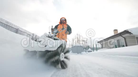 冬天男人用清扫车清扫院子里的积雪视频的预览图