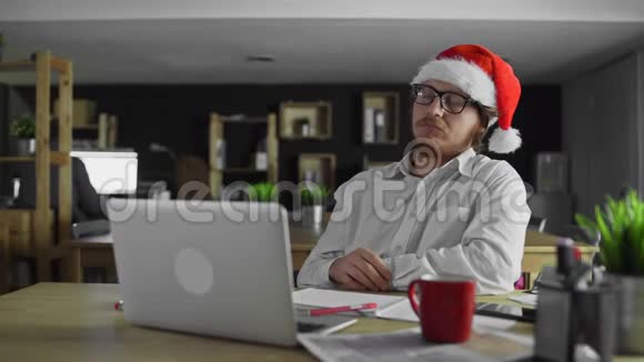 疲倦困乏的商人圣诞节在办公室工作视频的预览图
