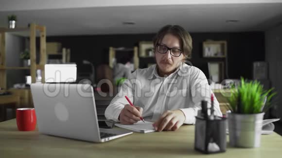 一个人坐在办公桌前写字视频的预览图