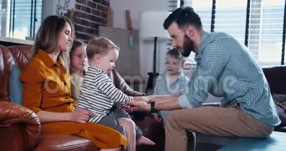 快乐年轻的白种人爸爸妈妈带着三个孩子携手为团队家庭亲密概念慢动作视频的预览图