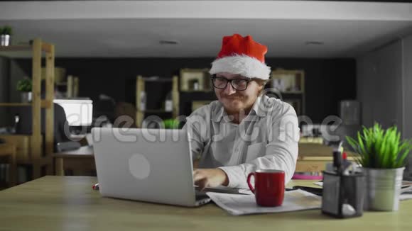 圣诞节经理心情很好在办公室里用笔记本电脑工作视频的预览图