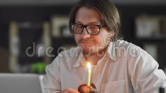 经理庆祝一个孤独的生日在办公室里吹灭一支蜡烛视频的预览图