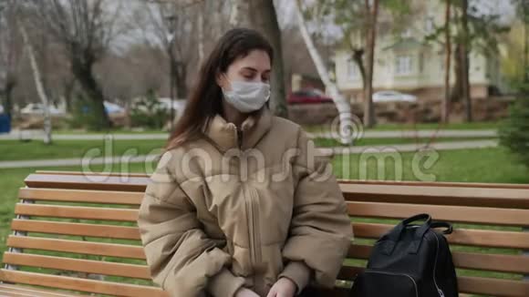 女性佩戴一次性医用口罩用消毒器消毒双手病毒的流行流行病视频的预览图