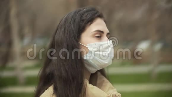 户外年轻女性的侧视带医用口罩以保护病毒概念冠状病毒大流行SARS视频的预览图