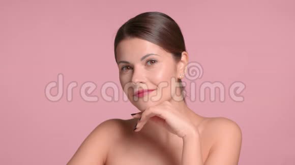 30岁的黑发女人在画室里穿着一件精致的装饰上衣上面有理想的粉色背景视频的预览图