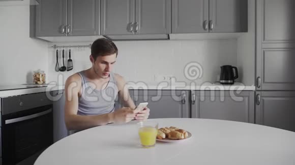 年轻人喝橙汁手里拿着智能设备每天早上都有帅哥坐在那里视频的预览图